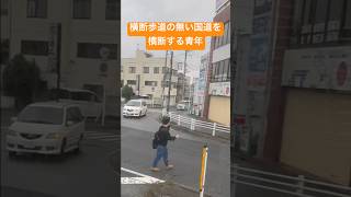 横断歩道の無い国道を横断する青年