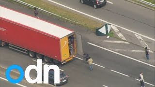 Migrants jump onto moving lorry amid Calais travel chaos