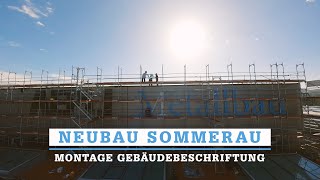 Neubau Sommerau: Montage Gebäudebeschriftung