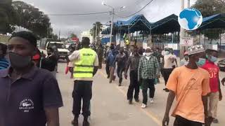 Likoni ferry commuters embark at the watch of police officers