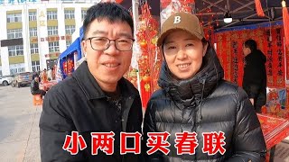 小两口赶集买春联，整条街人山人海，大红灯笼高高挂，年味十足