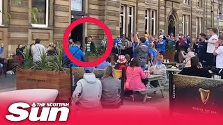 Brave Celtic fan strolls through Rangers supporters in George Square brushing off taunts and boos