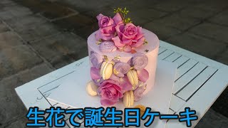 新鮮な花とマカロンの美しいバースデーケーキ