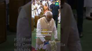 PM Modi touches the Constitution of India with his forehead at the NDA Parliamentary Party meeting