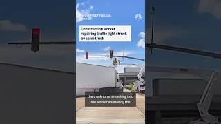 Construction worker repairing traffic light struck by semi-truck