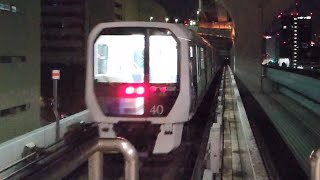 夜の芝浦ふ頭駅を出発してレインボーブリッジへ登るスロープへ向かっていくゆりかもめ下り7300系