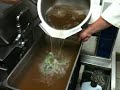 pouring 6 gallons of beef pho broth for storage