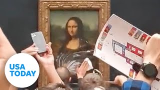 Man throws cake at Mona Lisa painting at Louvre Museum in Paris | USA TODAY