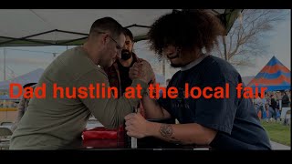 Dad Arm wrestling strangers at the local fair for prizes.