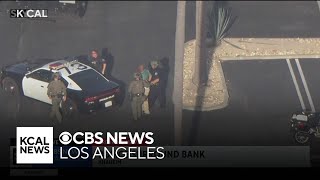 Police lead people out of the Anaheim bank after responding to an attempted bank robbery