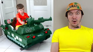 Senya drives a tank and shoots in toys. Funny stories for kids