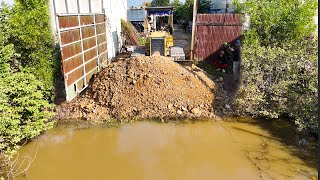 Great Bulldozer D31 pushing soil and filling land here with dump trucks