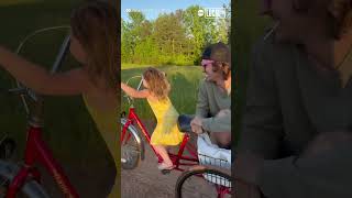 Girl rides bike with dad in tow