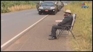 President Museveni answers a phone call by the roadside