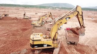 Five Caterpillar Excavators And A Fleet Of 4 Axle Trucks Working On A Huge Mining Area - Aerial View