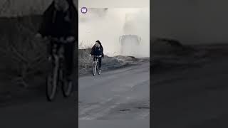 Crazy moment man in Ukraine cycles past a HIMARS launch