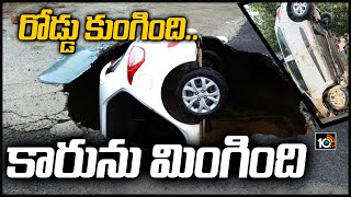 రోడ్డు కుంగింది.. కారును మింగింది | Road caves in Dwarka due to incessant rain, car got stuck inside