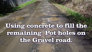 Using Concrete to fill remaining Potholes in the Gravel road.