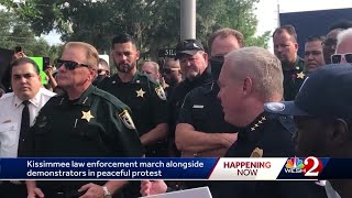 Law enforcement marches alongside demonstrators in peaceful protest