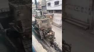 An IDF D9 bulldozer in a Gaza street, successfully detonating a hidden, boobytrapped IED