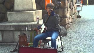 Japanese man playing Shamisen at Osaka Castle