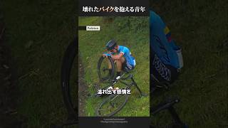 壊れたバイクを抱えながらレースを続ける青年