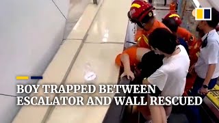 Boy trapped between escalator and wall rescued by firefighters in China