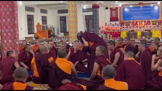 གདན་ས་ཆེན་མོ་རྣམ་གྲོལ་གླིང་དུ་ཆོས་ལུགས་རིས་མེད་ཀྱི་བགྲོ་གླེང་སྐབས་སུ་མཁས་དབང་རྣམས་རྩོད་པ་རྩོད་སྐབས། 