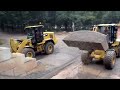 cat 938k digging into stone pile