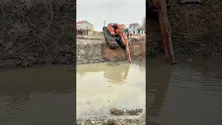 Excavator Climbing Out Of A River Up A Steep Dirt Slope