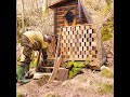 a house made of pallets in the forest.